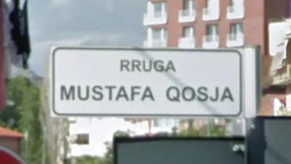 Албанская улица rruga с дорожным знаком на перекрестке