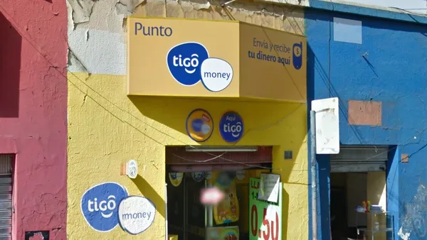 Синий логотип Tigo на рекламном щите в городской местности