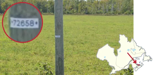 Небольшая белая наклейка на столбе на Острове Принца Эдуарда