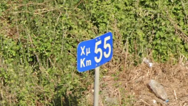 Синие греческие километровые указатели km на левой стороне дороги