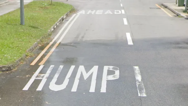 Крупные дорожные предупреждения на дороге HUMP AHEAD впереди кочка