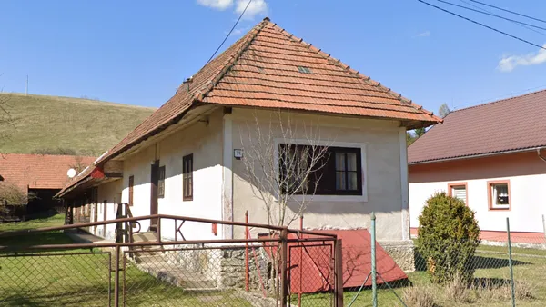 Словацкий дом с четырехскатной крышей, обращенной короткой стороной к дороге