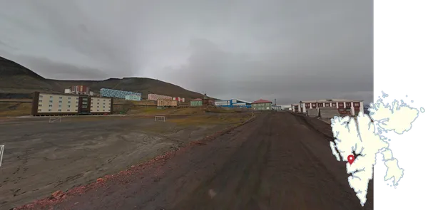 Разноцветные многоэтажные дома у подножия холма в Баренцбурге