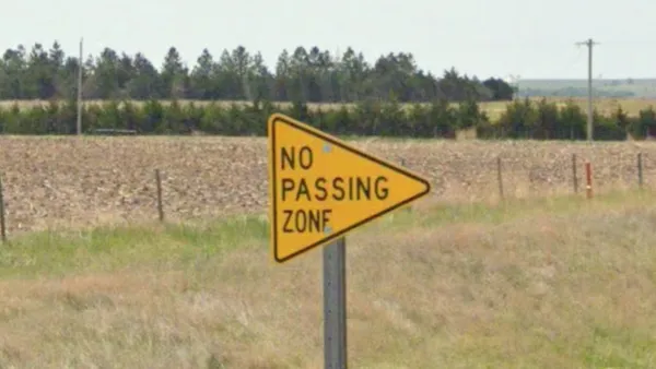 Треугольные желтые знаки No Passing Zone на дороге в США